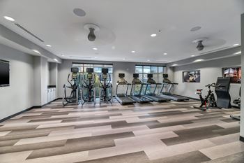 A gym with treadmills, exercise bikes, and other equipment.